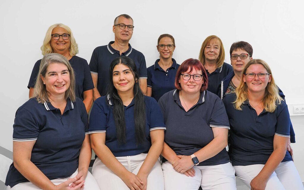 Praxis und Team, Grupppenfoto aller Mitarbeiter in blauen Poloshirts