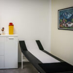 Behandlungsraum Praxis Dr. Schencking, mit Behandlungsliege und einem weißen Schrank